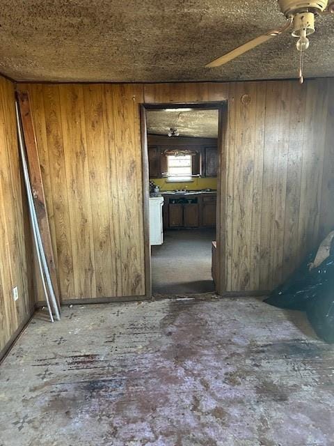 spare room featuring ceiling fan and wood walls