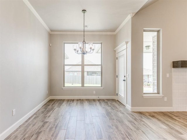 unfurnished dining area with plenty of natural light, an inviting chandelier, and light wood-type flooring