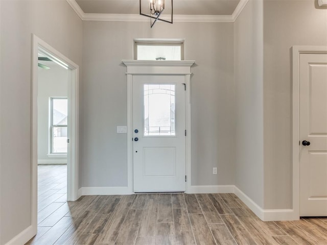 entrance foyer with light hardwood / wood-style flooring, a notable chandelier, and ornamental molding