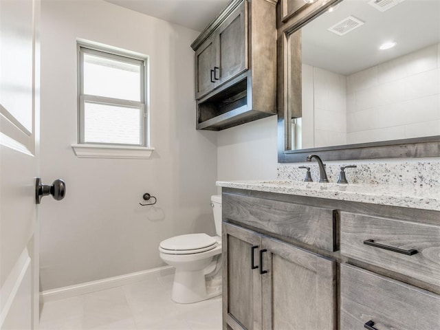 bathroom with tile patterned flooring, vanity, and toilet