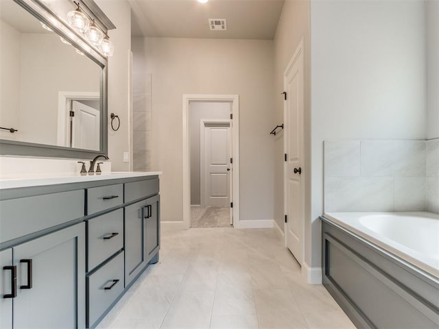 bathroom featuring tile patterned floors, vanity, and a tub