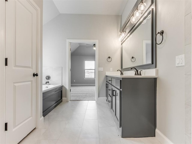 bathroom featuring ceiling fan, a washtub, tile patterned flooring, lofted ceiling, and vanity