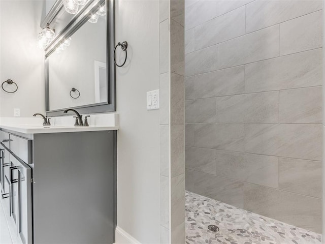 bathroom with tiled shower and vanity