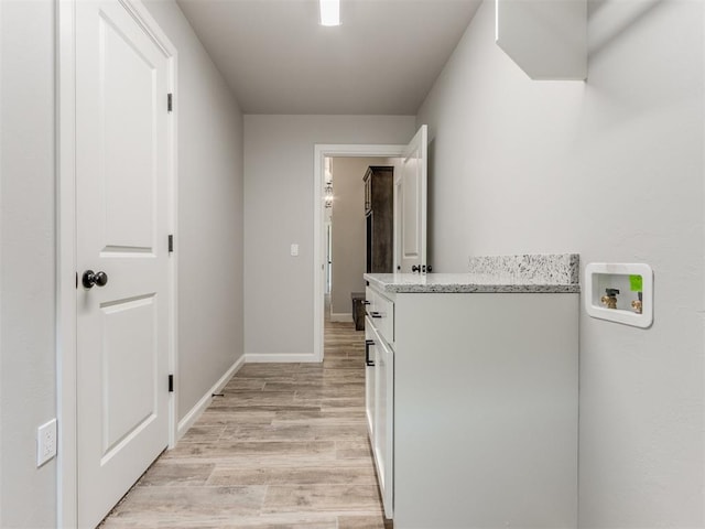 laundry area featuring cabinets, light wood-type flooring, and hookup for a washing machine