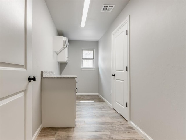 clothes washing area featuring light wood-type flooring