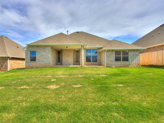 rear view of house featuring a yard