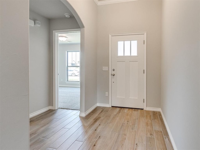 foyer entrance with a healthy amount of sunlight, light hardwood / wood-style floors, and crown molding