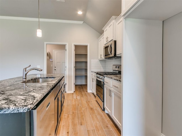 kitchen with dark stone counters, sink, light hardwood / wood-style floors, white cabinetry, and stainless steel appliances