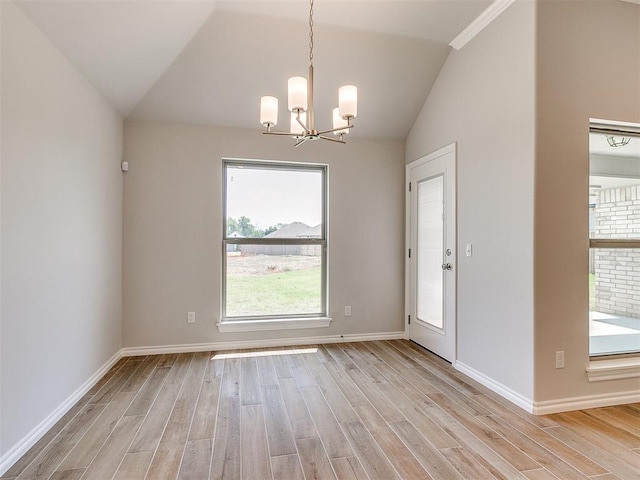 empty room with a notable chandelier, lofted ceiling, and light wood-type flooring