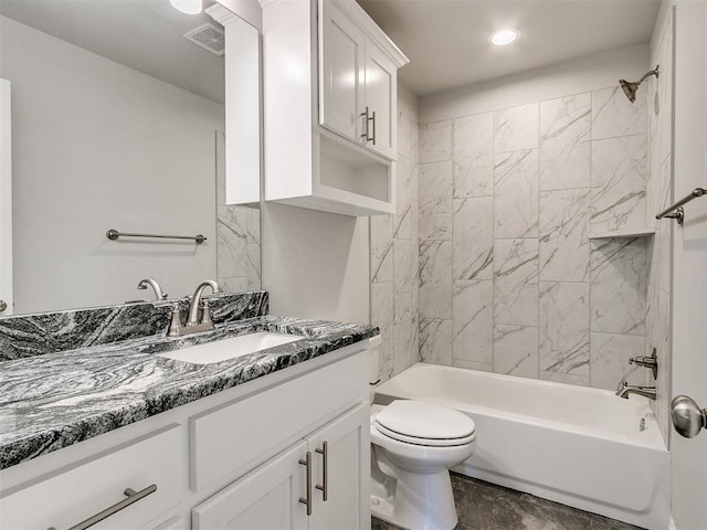 full bathroom featuring tiled shower / bath, vanity, and toilet