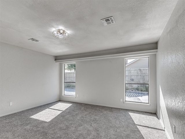 carpeted spare room featuring a textured ceiling