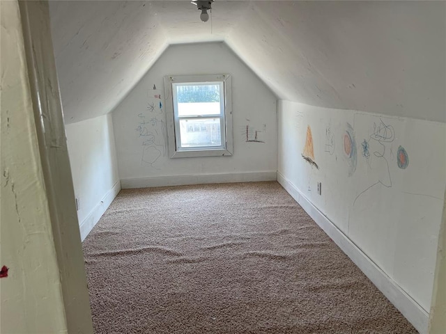 additional living space featuring light colored carpet and lofted ceiling