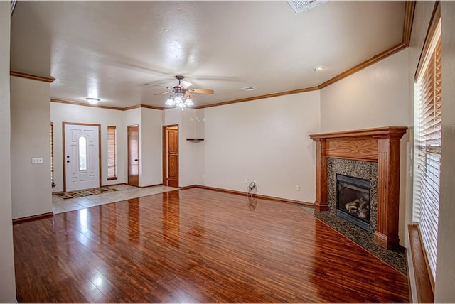 unfurnished living room featuring hardwood / wood-style floors, ceiling fan, crown molding, and a fireplace