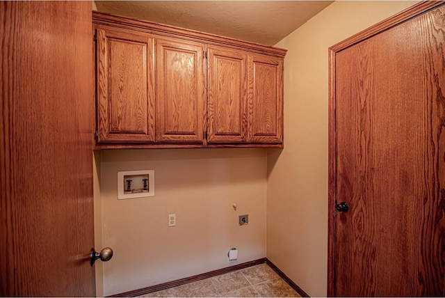 laundry room with hookup for an electric dryer, cabinets, light tile patterned floors, and hookup for a washing machine