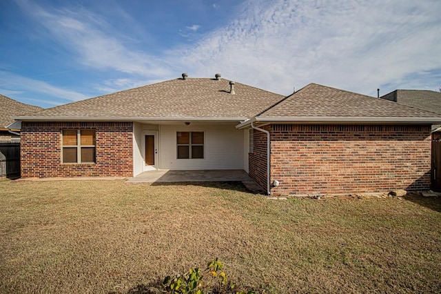 rear view of house featuring a lawn and a patio