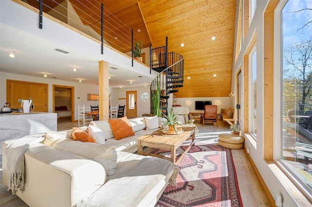 living room with plenty of natural light, light hardwood / wood-style floors, wooden ceiling, and high vaulted ceiling