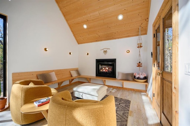 living room with light hardwood / wood-style floors, wooden ceiling, and high vaulted ceiling