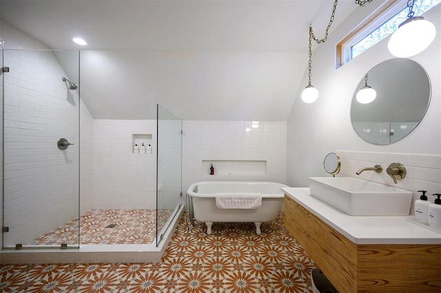 bathroom featuring shower with separate bathtub, lofted ceiling, sink, and tile walls