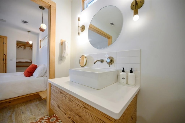 bathroom featuring decorative backsplash, hardwood / wood-style floors, and vanity