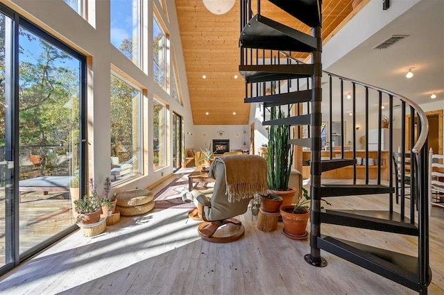 stairs with hardwood / wood-style floors, wood ceiling, and high vaulted ceiling