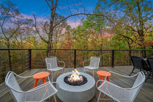 deck at dusk featuring an outdoor fire pit