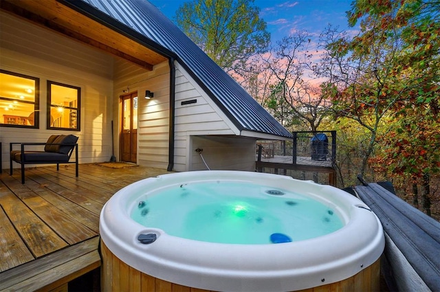 deck at dusk with a hot tub