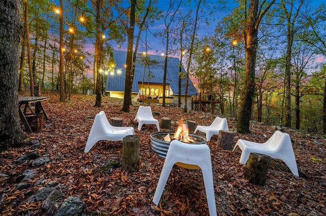 yard at dusk featuring an outdoor fire pit