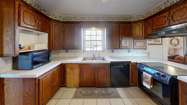 kitchen featuring exhaust hood, decorative backsplash, sink, and black appliances