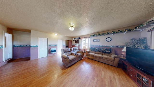 unfurnished living room featuring light hardwood / wood-style flooring and a textured ceiling