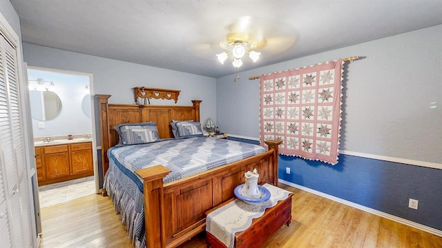 bedroom with ensuite bath, ceiling fan, light hardwood / wood-style flooring, and sink