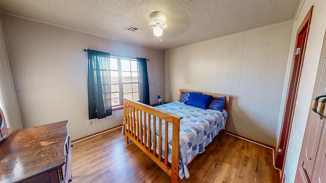 bedroom featuring wood-type flooring, a textured ceiling, and ceiling fan