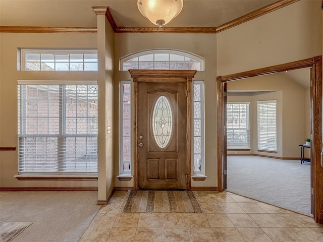 foyer entrance with light carpet and ornamental molding