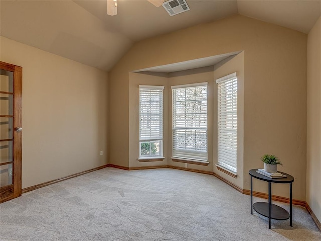 carpeted spare room featuring lofted ceiling and ceiling fan