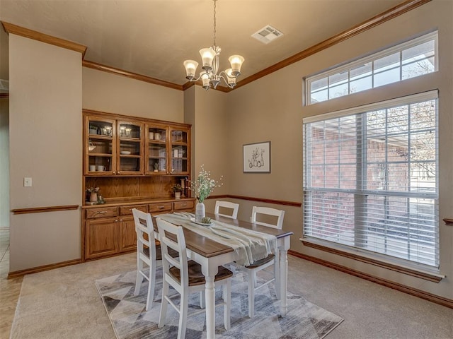 dining space featuring an inviting chandelier, ornamental molding, and light colored carpet