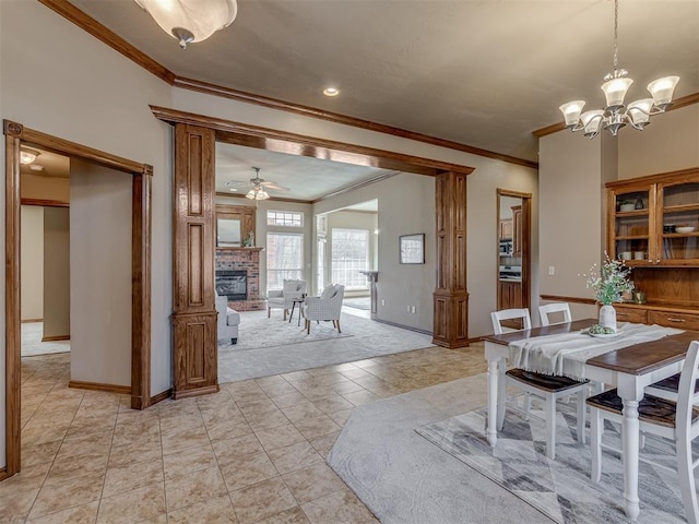 dining space featuring crown molding, ceiling fan with notable chandelier, a fireplace, and light tile patterned flooring