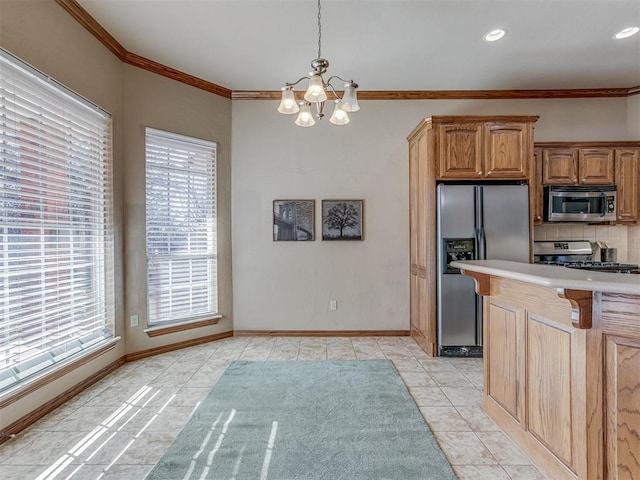 kitchen featuring appliances with stainless steel finishes, decorative light fixtures, tasteful backsplash, ornamental molding, and light tile patterned floors