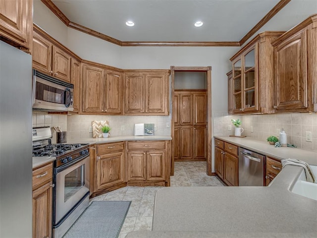 kitchen featuring tasteful backsplash, ornamental molding, and appliances with stainless steel finishes