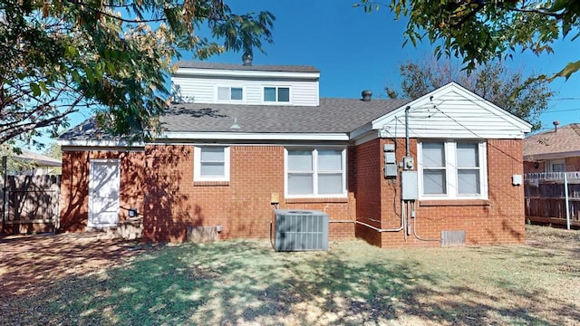 back of house featuring central air condition unit and a yard