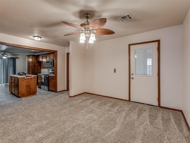 unfurnished living room featuring light colored carpet and ceiling fan