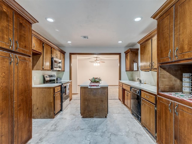 kitchen with ceiling fan, appliances with stainless steel finishes, a center island, and sink