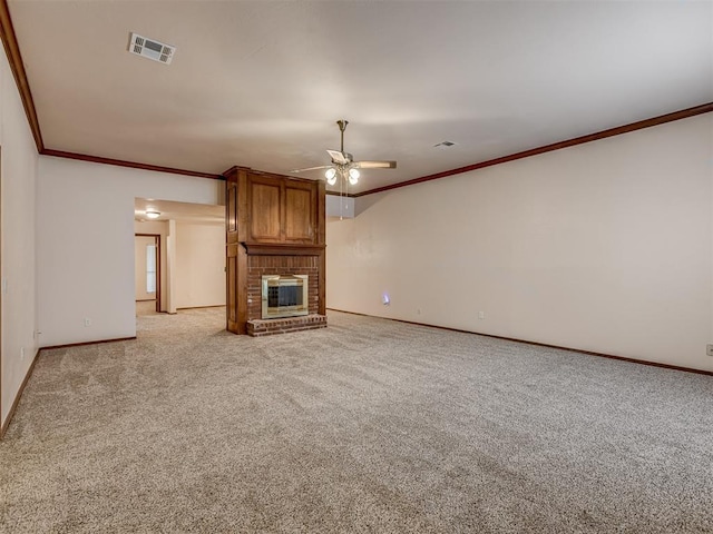 unfurnished living room featuring crown molding, a brick fireplace, light colored carpet, and ceiling fan