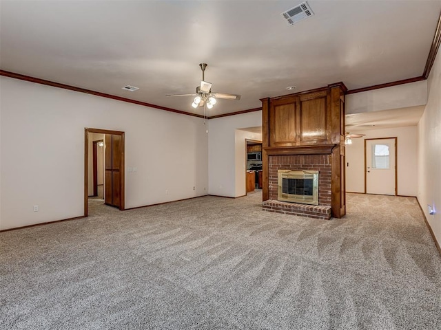 unfurnished living room with ceiling fan, ornamental molding, light carpet, and a brick fireplace