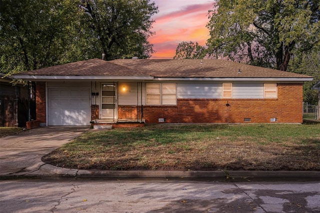 ranch-style home with a lawn and a garage