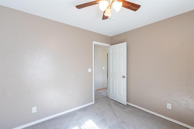 empty room with ceiling fan and light carpet