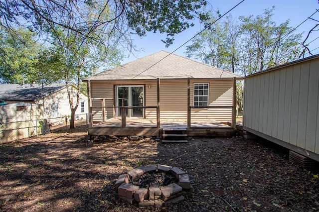 rear view of property featuring an outdoor fire pit and a wooden deck