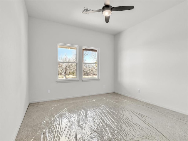 empty room with ceiling fan and light carpet