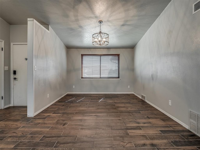 unfurnished dining area with dark hardwood / wood-style floors and an inviting chandelier