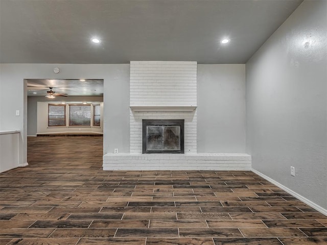 unfurnished living room featuring dark hardwood / wood-style floors and a brick fireplace