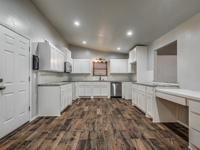 kitchen with white cabinetry, dark wood-type flooring, appliances with stainless steel finishes, and vaulted ceiling