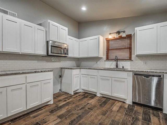 kitchen featuring dark wood-type flooring, white cabinets, sink, tasteful backsplash, and stainless steel appliances